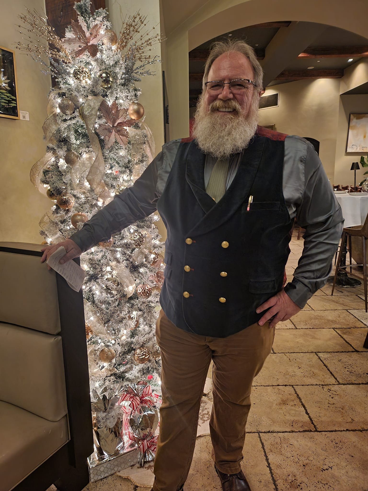 Stage Christmas Party — Jeffry by the tree in vest and shirtsleeves, holding the evening&rsquo;s paper, Sat · Dec 16, 2023