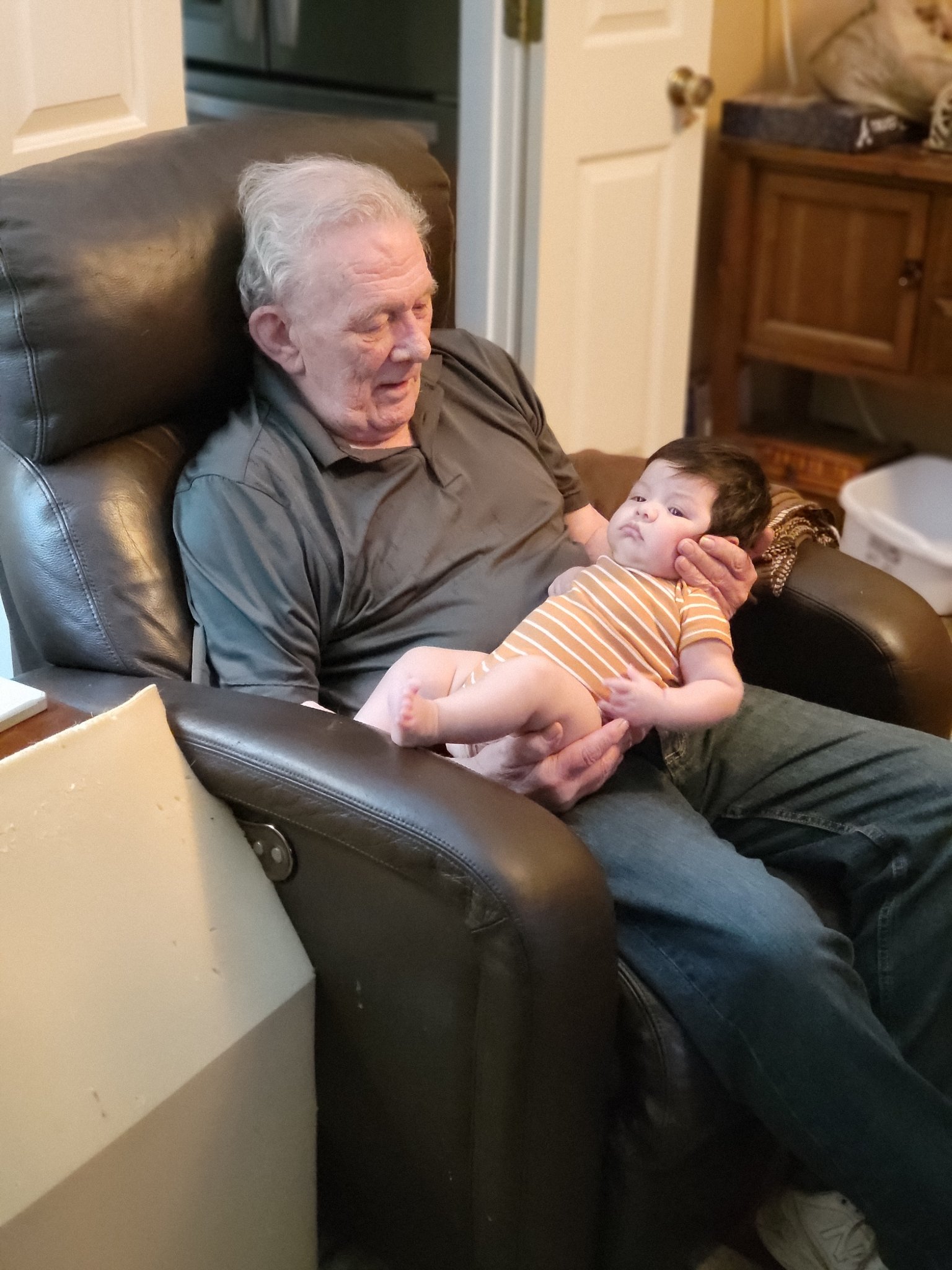 A visit with the grandkids — Bob in his recliner cradling baby Aries, Sun · Aug 18, 2024
